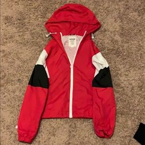 A black white and red jacket with hood and pockets